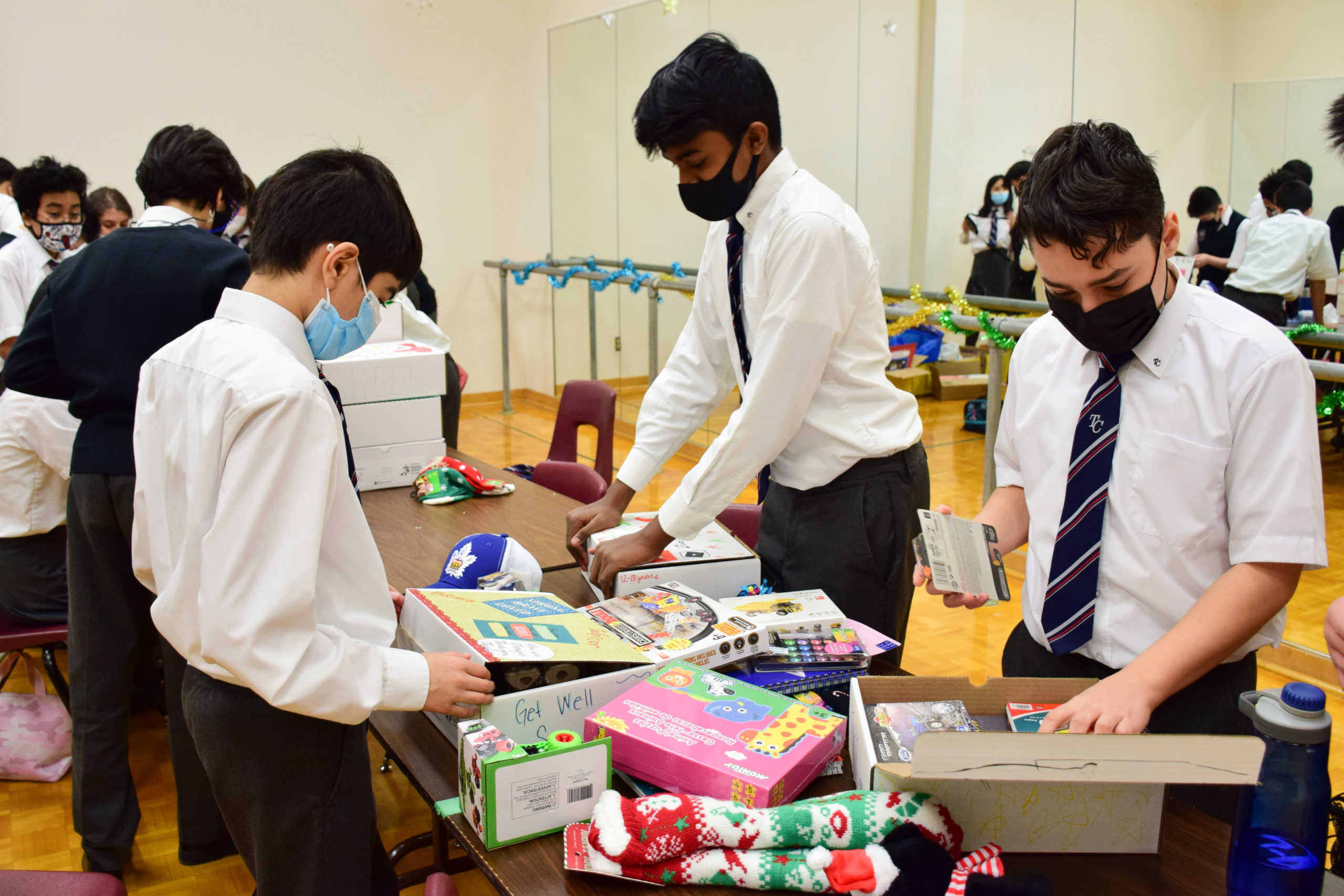 Elementary students packing gift boxes