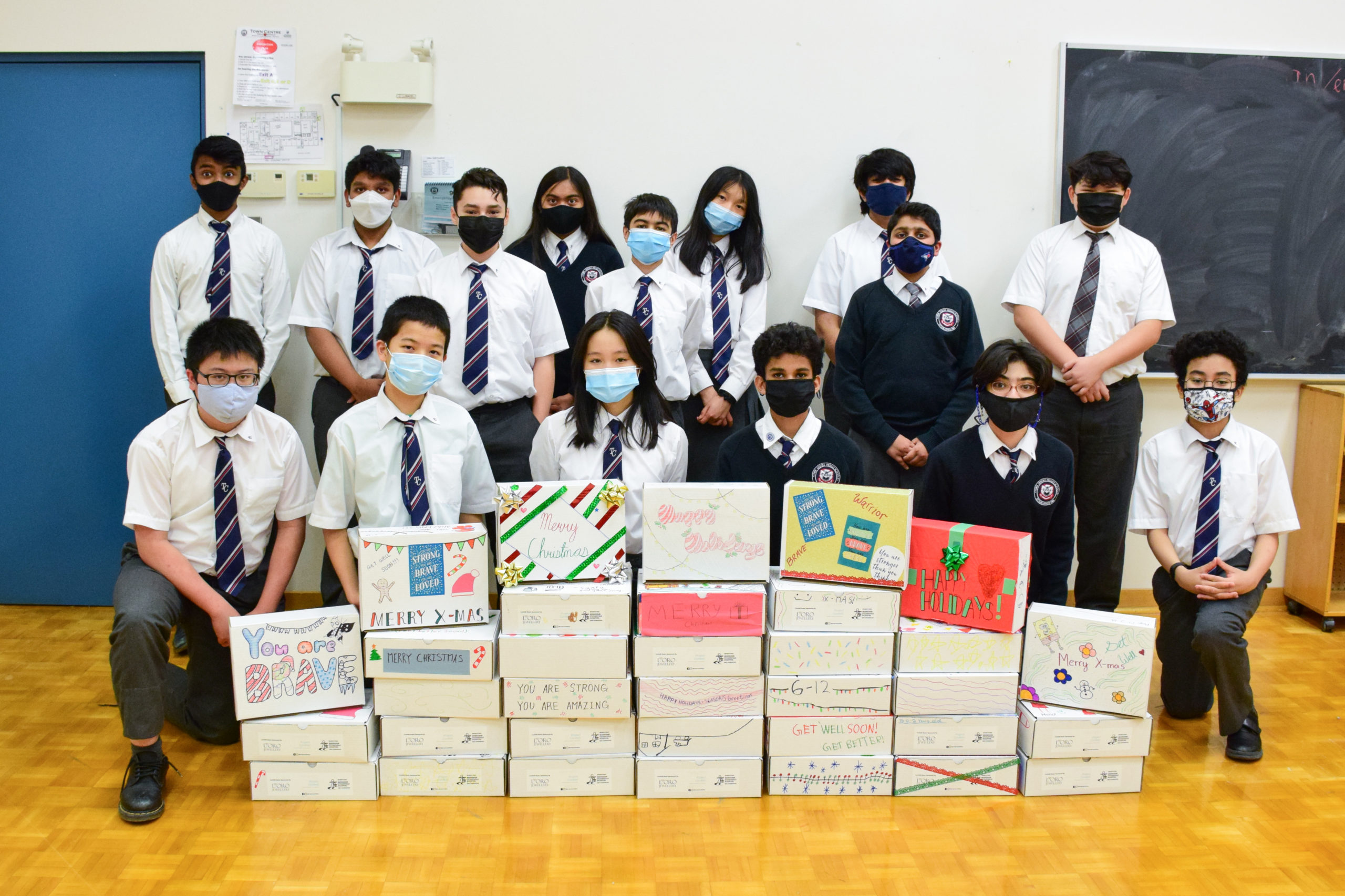 elementary students showing the boxed donations for project confetti